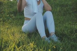 Young fitness woman runner stretching legs before run on city photo