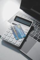 Calculator on a dark background, plastic cards and banknotes photo