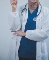 Doctor wearing white coat and watching patient data in Tablet . photo