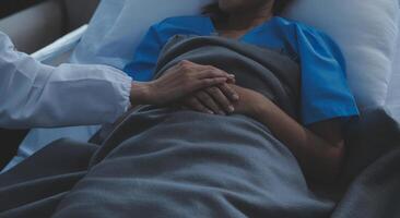 Cropped shot of a female nurse hold her senior patient's hand. Giving Support. Doctor helping old patient with Alzheimer's disease. Female carer holding hands of senior man photo