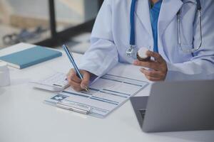 Cropped view of doctor in white coat holding bottle medication, prescribing pills to sick patient via online consultation. Family therapist recommend quality medicines. Healthcare, treatment concept photo