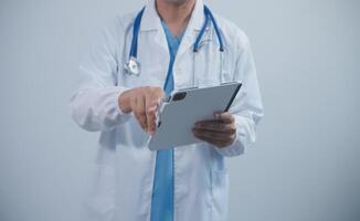 Mature male doctor with tablet pc is giving presentation. Blurred background indoors. photo