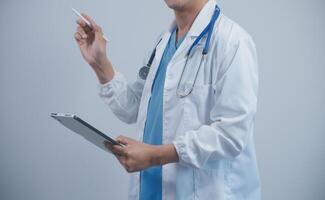 Mature male doctor with tablet pc is giving presentation. Blurred background indoors. photo