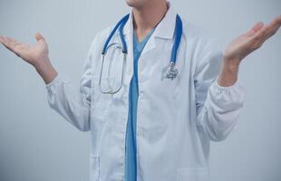 Mature male doctor with tablet pc is giving presentation. Blurred background indoors. photo