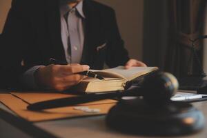 Business and lawyers discussing contract papers with brass scale on desk in office. Law, legal services, advice, justice and law concept picture with film grain effect photo