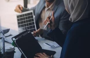 verde energía negocio empresa reunión con negocio personas planificación y discutir márketing de sostenible y renovable limpiar energía producto con solar célula y viento turbina generador. pionero foto