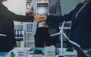 Two business executives, elegantly attired in suits, join hands in a gesture of unity, solidarity, and shared commitment towards a common goal or venture. photo