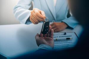 Insurance officers hand over the car keys after the tenant. have signed an auto insurance document or a lease or agreement document Buying or selling a new or used car with a car photo