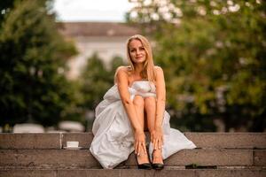 mujer ciudad frazada. Mañana en el grande ciudad. un rubia mujer en un blanco cobija es disfrutando en el ciudad centro. fotografiado para social medios de comunicación foto