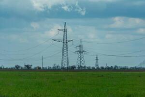 High voltage towers with sky background. Power line support with wires for electricity transmission. High voltage grid tower with wire cable at distribution station. Energy industry, energy saving photo
