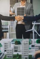 Two business executives, elegantly attired in suits, join hands in a gesture of unity, solidarity, and shared commitment towards a common goal or venture. photo