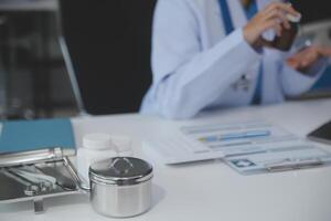 Cropped view of doctor in white coat holding bottle medication, prescribing pills to sick patient via online consultation. Family therapist recommend quality medicines. Healthcare, treatment concept photo