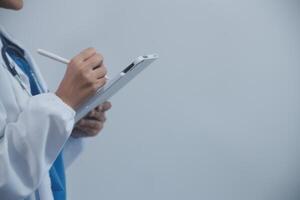 Woman doctor using tablet computer while standing straight in hospital photo