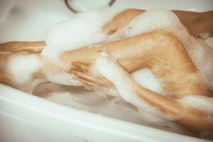 Women's feet in bath foam. View from above. Enjoy and relax in a spa hotel photo