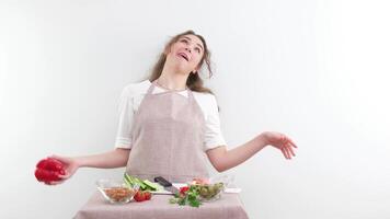 komisk i som flicka träffar själv på panna med peppar och skjuter bort diet matlagning sallad räcker ut hår skrattande vit bakgrund Ingredienser grönsaker vegetarian mat skämt glädje roligt video