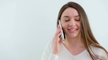 lindo menina voltas a telefone dentro dela mãos a partir de uma horizontal posição para uma vertical branco fundo publicidade escrever tipo SMS conectados comunicação doce mulher □ Gentil mãos estar h3althy video