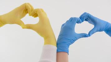 vertical de manos en quirúrgico guantes haciendo corazón forma en azul antecedentes con Copiar espacio. salud conciencia, médico cuidado, apoyo y cuidado de la salud servicios concepto. video