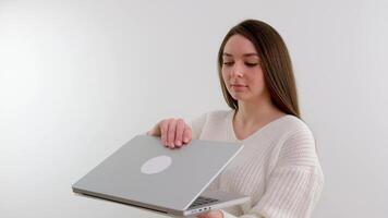 Mädchen halten Neu Gadget im Hände öffnen Laptop Start Tippen Passwort aussehen lächelnd schön süß Frau im Hände mit neueste Technologie Internet Sozial Netzwerke Kommunikation video