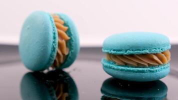 wirbelnd Blau Macaron Lavendel oder bru Käse Geschmack auf schwarz Teller wirbelnd köstlich Dessert Restaurant Portion Süße Französisch Dessert Mittagessen Koch Gericht viele von Belag Mandel Mehl schleppend Bewegung video