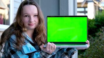 Tonårs flicka i händer med bärbar dator grön skärm krom nyckel annons tonåring sitta på veranda på Hem söt ansikte anbud leende ad se här välja detta härlig produkt nöjd Lycklig Bra utseende verklig människor video