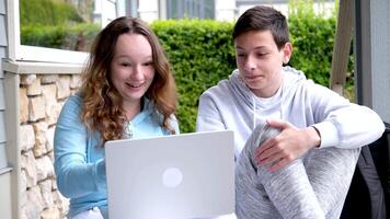 agréable relation adolescents garçon et fille Faire cours ensemble sur portable en riant parlant séance à l'extérieur agréable mignonne des gamins gens spectacle joie tendresse la communication mallette Canada Amérique video