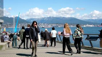 Canadá Lugar, colocar andar ao longo a passeio falando em a telefone oculos de sol lanches almoço levando fotos real vida dentro uma grande cidade dentro uma pacífico porta perto a montanhas dentro Primavera dentro Canadá Vancouver video