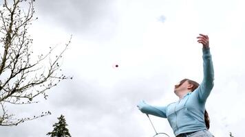 barn tonåringar Pojkar flicka spelar badminton utomhus på gata mot körsbär blommar resten avslappning vår sommar spendera trevlig tid har roligt spelar sporter spel vänner klasskamrater skola ålder video