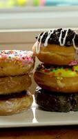 dichtbij omhoog gebaar van hand- maken en decoreren eigengemaakt donuts. video
