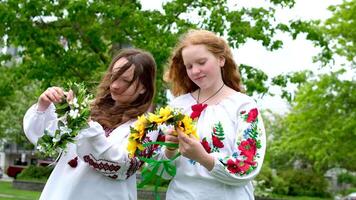gammal ukrainska traditioner vävning kransar på ivan kupala två flickor med skön röd hår under vind är framställning för kväll solnedgång sjösättning skön blommig dekorationer broderad shirts video
