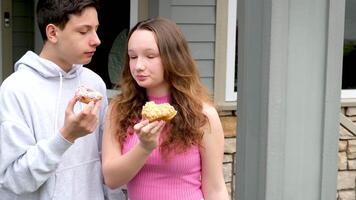 children tasting fingers on the porch girl biting from boy's hands delicious dessert wide open mouth friends having fun chatting kindness share with friend video