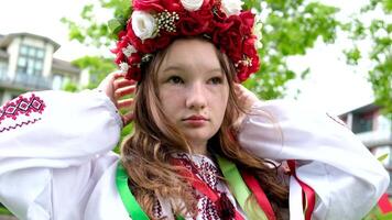hermosa ucranio joven mujer oferta niña en un grande rojo guirnalda de brillante rosado blanco rojo flores trenza cintas en pelo viento sensibilidad limpieza paz en Ucrania tiempo de paz personas real vida video