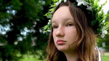schön Frau mit ein Kranz auf ein Grün Wiese ukrainisch Mädchen mit ein Kranz von Blumen video