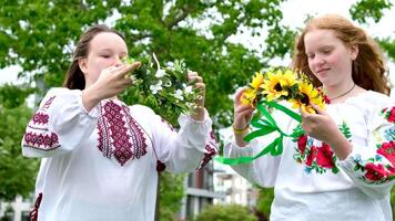 Ivana Kupala summer two girls friends put on their heads beautiful wreaths with numerous flowers Ukrainian folk dressing joy friend love beauty folk customs nature sunny strong wind video