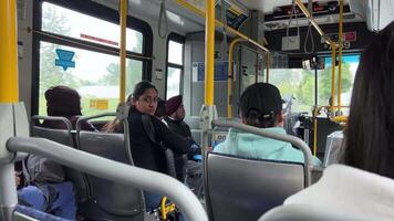 gens de différent nationalités vivre dans le ville de Vancouver asseoir sur le autobus Regardez devant le autobus va à surrey émigrants réfugiés réel la vie de réel gens video