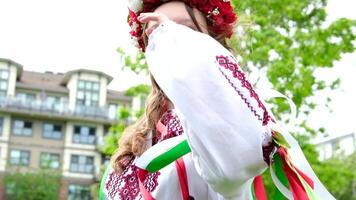 süß jung Mädchen Teenager ukrainisch Frau im Volk traditionell entwickelt ihr Locken schön Kranz mit viele Blumen Bänder Natur weiblich natürlich Schönheit Volk Bild Natur Bäume Laub Frau video