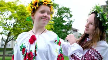 Kommunikation von zwei Mädchen im ukrainisch National Kleider Flechten flechten Stehen mit Kränze im Hände Putten schön Kranz auf Kopf Sonnenblumen Wald Blumen Stickerei auf Ärmel Blusen Frauen video