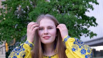 lindo ucraniano mulher dentro uma amarelo azul bordado camisa parece para dentro a quadro, Armação sorrisos endireita fechar-se face brincos dentro a Formato do a bandeira do Ucrânia vitória Diversão alegria força liberdade vai video