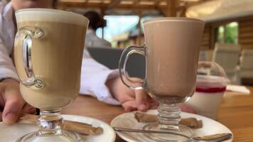 dos vaso tazas en mesa con caliente bebidas cacao y latté comparación de color y gusto niña cambiando lugares en blanco platos delicioso comida servicio siguiente a el plastico envase jalea café en calle video