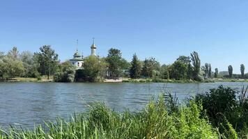 Vinnitsa view of the embankment on the Kiev bridge church green reeds Clear water of the Southern Bug blue sky Ukraine Peacetime video