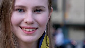 des boucles d'oreilles dans le forme de le ukrainien drapeau Jaune et bleu Couleur Jeune fille dans une Jaune brodé chemise fermer Môle au dessus le lèvre manifestation à vivre dans paix l'amour pour la vie Ukraine video