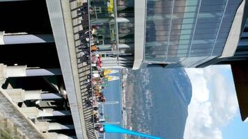 Sie können sehen das Statue von ein fallen von das Pazifik Ozean Restaurants Cafés Glas Büro Gebäude Berge Weiß Wolken Menschen Gehen entlang das Damm Möwe fliegend im das Himmel Hafen Kanada Platz video