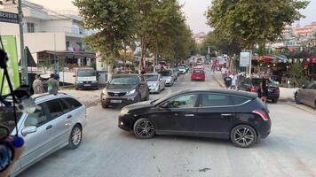 Albanië ksemil 09.09.2023 verkeer Aan de straten de beweging van mensen en auto's motorrijders blokkeren de weg verkeer jam mensen toeristen in de stad van ksamil een veel van auto's in de versmallen straten video