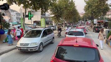 Albania ksemil 09.09.2023 tráfico en el calles el movimiento de personas y carros motociclistas bloqueo el la carretera tráfico mermelada personas turistas en el ciudad de ksamil un lote de carros en el estrecho calles video