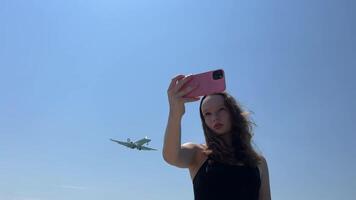een jong tiener- meisje telefoon en schiet een van hoe een groot vlak vliegt reizen Europa Amerika tieners nieuw generatie van sociaal netwerken blog interessant kanalen vliegtuig vervoer beweging video