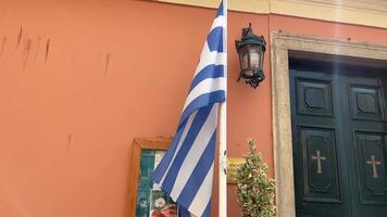 Grecia bandera ondulación en el viento marrón edificio en el antecedentes cristiano verde puertas Europa balcánico video