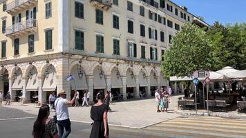 narrow streets tall yellow buildings on the island of Corfu tourists walking around the city magnets sale life is in full swing in a tourist city sky tall buildings Greece video