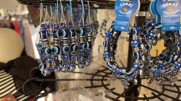 Griechenland Korfu Insel Magnete Halsketten Armbänder Geschenke und Souvenirs auf Verkauf Nahansicht Blau Farbe überwiegt video