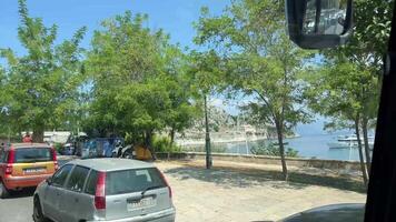 promenade de le île de corfou voitures qui passe gens en marchant méconnaissable gens la vie dans le ville touristes attractions Grèce video