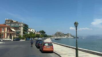 promenade de le île de corfou voitures qui passe gens en marchant méconnaissable gens la vie dans le ville touristes attractions Grèce video
