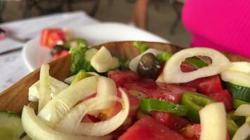 avec deux fourches il mélanges le salade avec beaucoup de tomates sur le assiette parmi le légumes, épices et huiles sont mixte donc cette elles ou ils sont uniformément distribué video